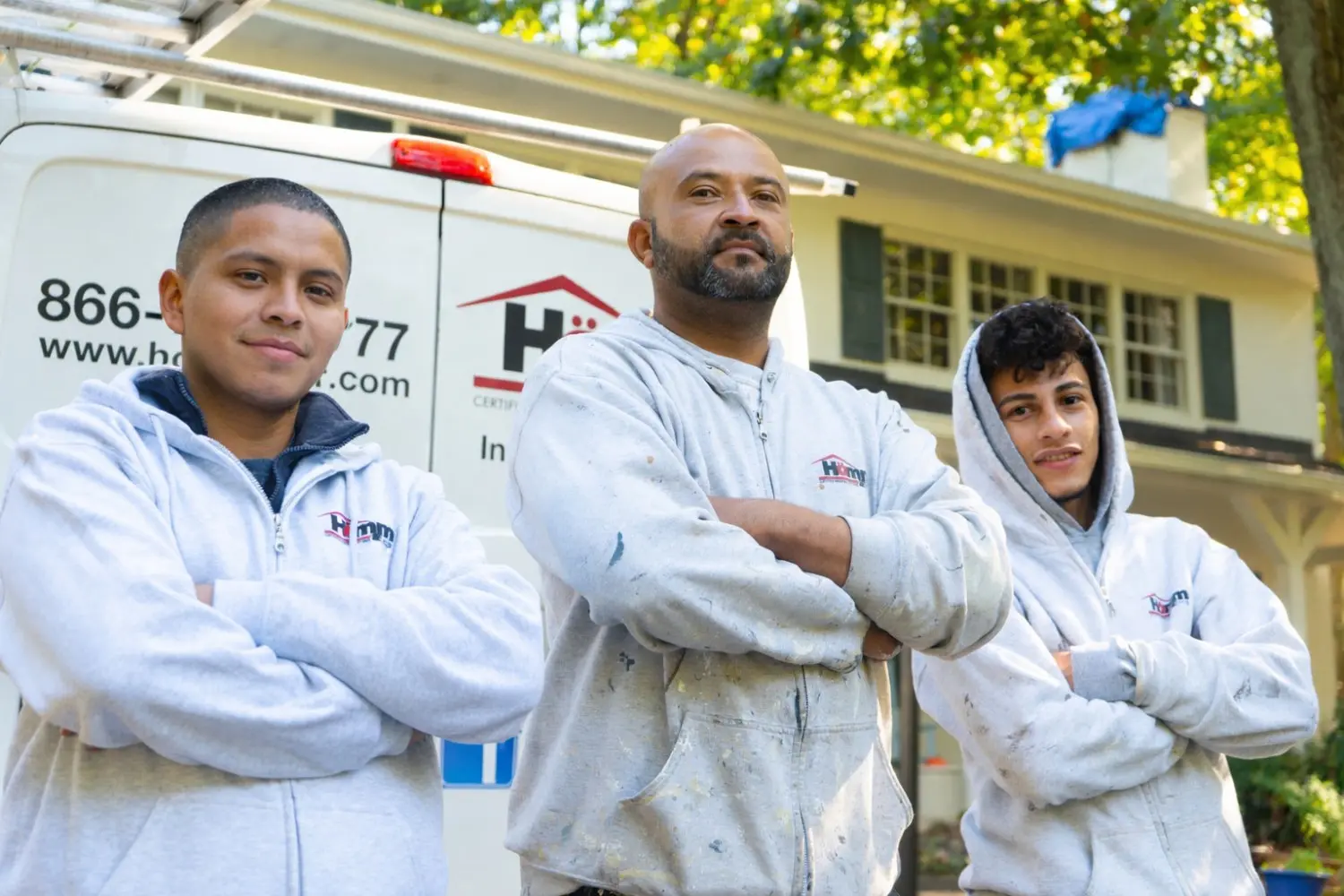 Professional home painters from Homm Certified Painting Systems standing by a company van in Alexandria, VA.
